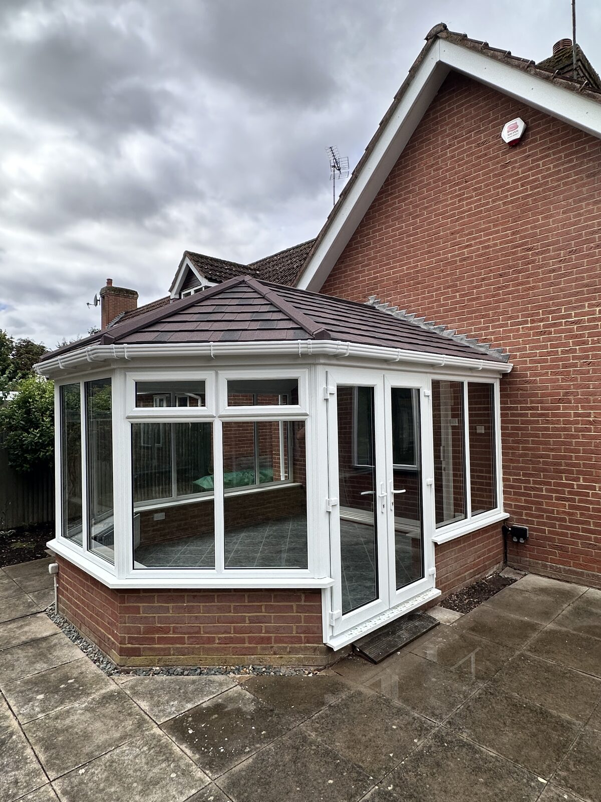 White conservatory in a garden setting